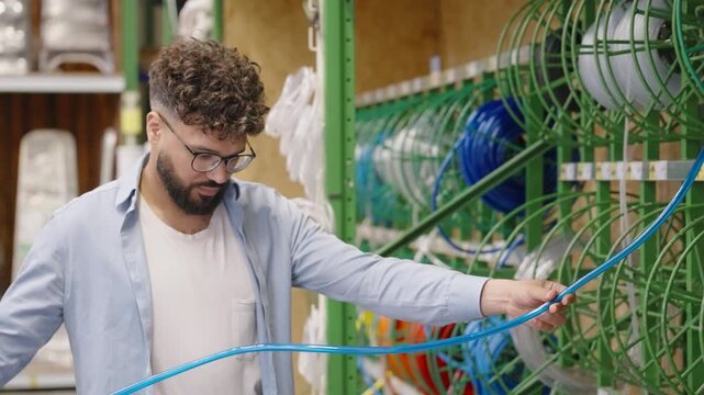 Man choosing plumbing pipe in hardware store