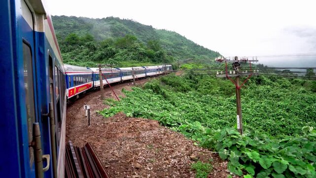 Traditional Blue and Red Train Traveling Through Scenic Vietnam Countryside Between Da Nang and Hue Landscape