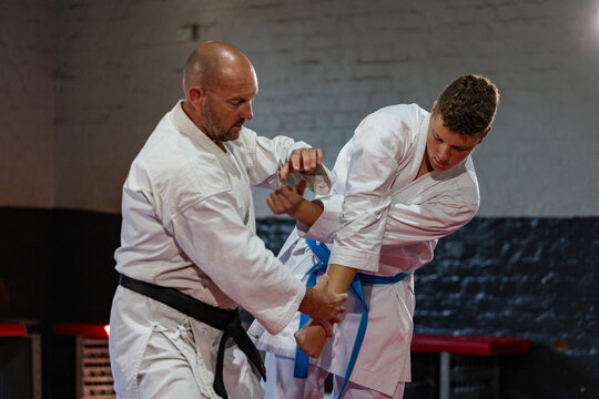 Karate instructor demonstrating grappling technique with student