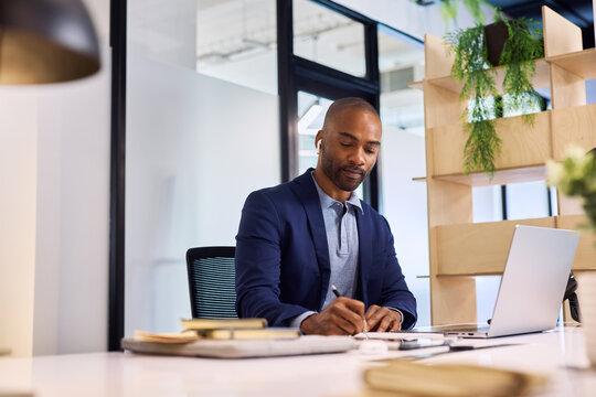 African american busy businessman taking notes at desk