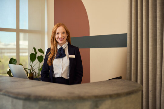 Portrait of beautiful receptionist smiling at front desk