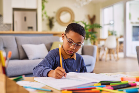 Black little elementary boy doing homework at home