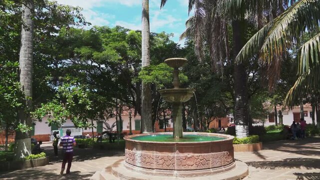 Barichara Santander Colombia Water rock fountain in central park with a person passing by in green nature