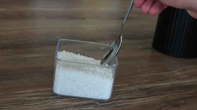 scoop of corse kosher salt falling, out of the scoop in to the pot, chef, kitchen