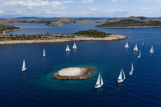 Aerial view of yachts regatta sailing around the rocky Taljuric islet in Telascica Nature Park, Croatia