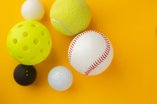 Assortment of Various Sports Balls on Vibrant Yellow Background