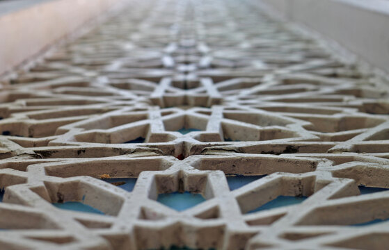Close-up of intricate Islamic geometric pattern screen with shallow depth of field