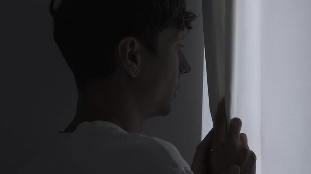 Surveillance and privacy fear concept with person secretly looking through curtain, being watched, spying and security anxiety atmosphere. Close up portrait