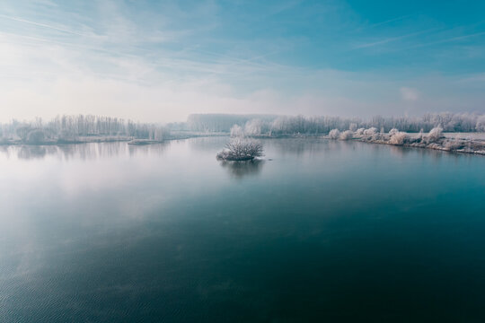 Paysage hivernal givr&eacute; au bord d'un lac calme, vue a&eacute;rienne