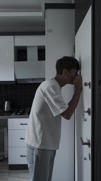 Obsessive checking and OCD symptoms concept with anxious man repeatedly looking through door peephole, fear, compulsive behavior and stress, close up vertical video