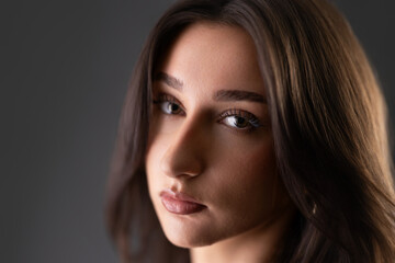 Fototapeta premium Young woman looking at camera with serious expression in beauty concept