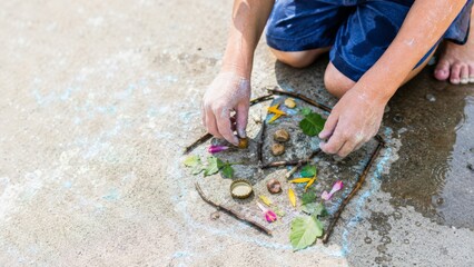 Child playing outside with natural materials in summer, connecting with nature © dvoevnore