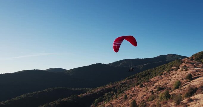 Paraglider Soaring Through the Sky at Sunset Over Scenic Landscape