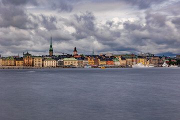 Obraz premium Stockholm Skyline and Gamla Stan Waterfront under Dramatic Storm Clouds