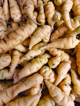 Top view of fresh raw yellow ulluco tubers or chuguas piled at a local traditional South American market