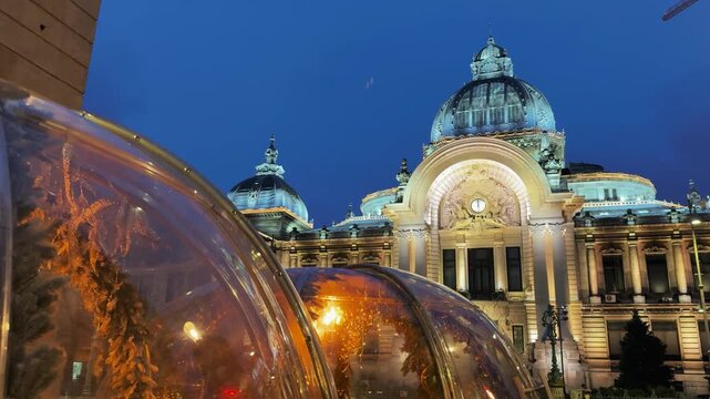 Illuminated CEC Palace in Bucharest at Dusk with Festive Structures