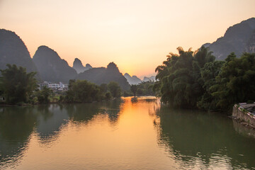 Obraz premium Sunset over Karst Mountains and River Valley