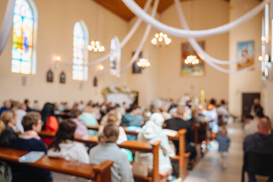 Blurred atmospheric photo of parishioners praying inside a cathedral, faith and traditional mass concept