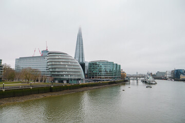 Fototapeta premium Londres - La Tamise, City Hall et le Shard sous ciel nuageux