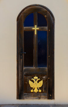 Detail of old wooden door with cross and double-headed eagle of traditional Greek Orthodox chapel of Agios Antonios in the village of Gouves, Crete. Travel concept, religion symbol