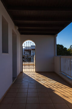 Architectural detail of a wrought iron metal gate in a Crete hotel with morning sunlight bursting through the bars