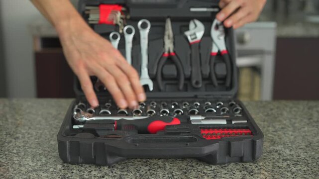 Close up man opening and closing toolbox with mechanical tools with clear sound. Hands handling equipment. Repair work, craftsmanship and maintenance routine concept.