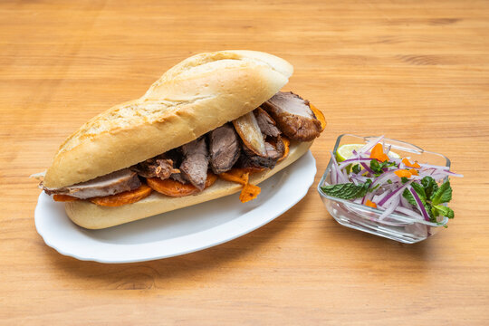 Arequipa-style torrezno served in irregular portions, with a partially melted layer of fat and extremely crispy skin, presented alongside cooked mote