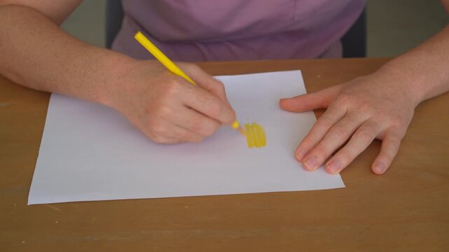 Woman coloring a sheet of paper with a colored pencil at a table, high quality audio recording. Soft pencil-on-paper sounds. Drawing, creativity, and everyday lifestyle concept.