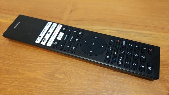 Banyuwangi, East Java, Indonesia - April 29 2026. Black TV Remote Control on Wooden Table