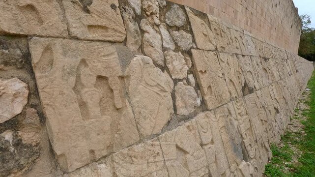 Ancient stone carvings on walls of Great Ball Court in Chichen Itza, Mexico. Detailed Mayan reliefs at historic stadium. Archaeology, heritage, culture and travel destination concept.