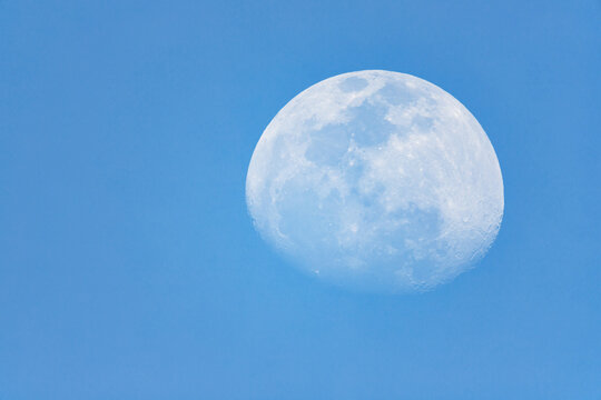 moon with craters texture in blue sky