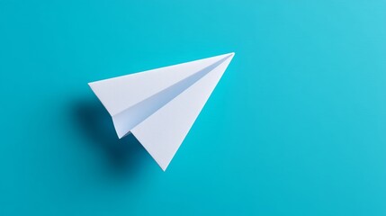 Single white paper airplane centered on blue backdrop. Minimalist travel and communication concept
