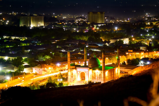 Osh central mosque kyrgyzstan timelapse day to night cityscape glowing green dome minarets urban lights residential district mountain backdrop dusk transition. Sulaiman - Too mountain
