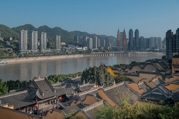 Traditional temple rooftops and modern skyline along the river in Chongqing China © PhungBao