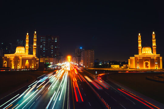 Night long exposure Sharjah Four Khalifas intersection.UAE futuristic architecture. Illuminated Masjid Abu Bakr Al Siddiq, Umar bin Al Khattab, Uthman bin Affan, Ali bin Abi Talib mosque light trails