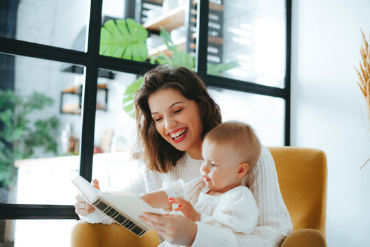Mother and baby engaging with book in bright living room