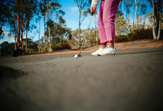 Golfer Prepares to Putt on a Sunny Day at Country Golf Course