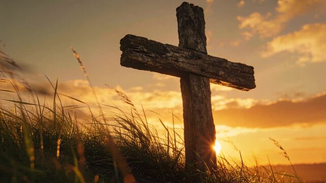 Lowering sun creating starburst flare behind weathered wooden cross on grassy bluff, moving grasses
