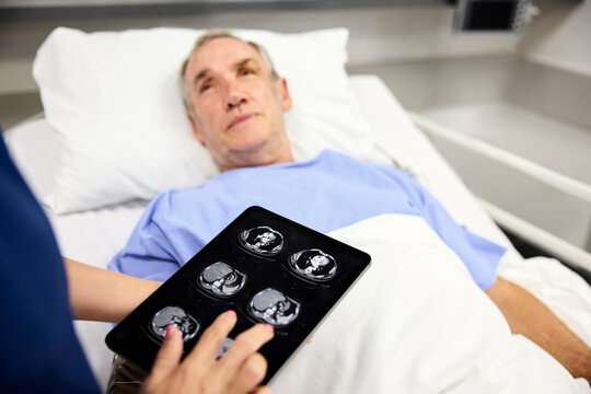 Doctor Shows Medical Scans to Patient in Hospital Room