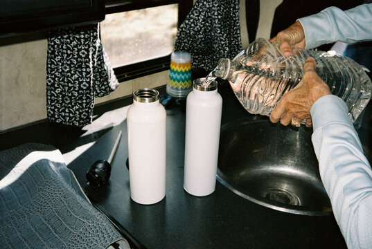 Woman filling water bottle for hike 