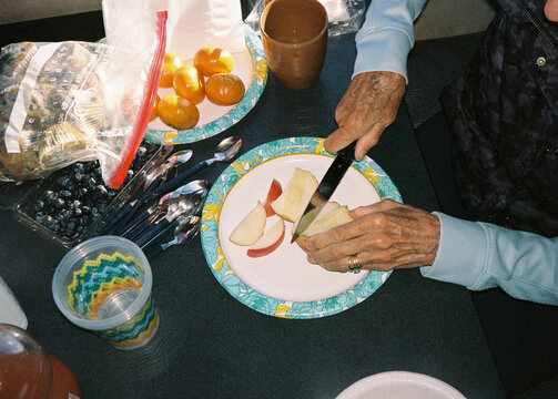 Senior woman cutting fruit for breakfast RV trip film
