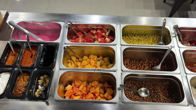 fresh food buffet counter displaying healthy salad ingredients and condiments