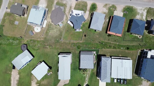 Dual row housing grid neighborhood east of Seashell Dr forms two parallel residential rows with spaced parcels, driveways, small outbuildings define inland layout. Mixed roof tones, Freeport, TX