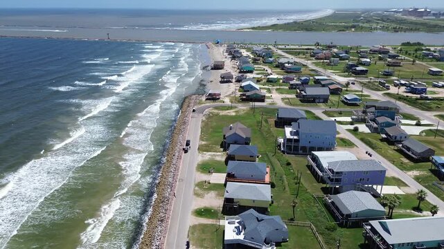 Blocks east of Seashell Dr extend toward jetty separating Gulf from inlet, showing dense coastal housing of vacation homes, short term rentals near ocean view Bluewater Highway. Freeport, TX
