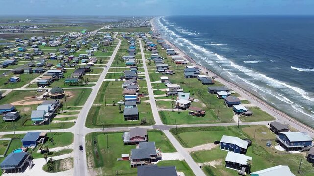 Shoreline housing band streets parallel to Gulf near Seashell Dr show elevated homes arranged along beach corridor with proximity to Bluewater Highway. Clean roof patterns, parcels, Freeport, TX