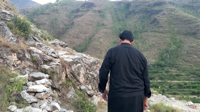 Young Asian teenage boy hiking outdoors while wearing simple slippers.