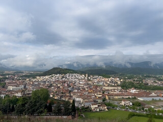 Fototapeta premium Olot city panorama with clouds covering mountains