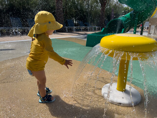 Toddler playing in water splash pad on summer vacation © Alberto Gonzalez 