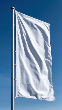 Blank white flag on flagpole waving in blue sky offering a clear template for custom branding, symbol of peace, surrender, or a fresh new beginning