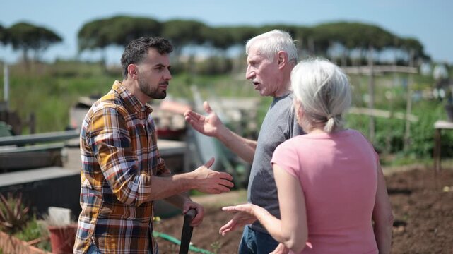 Mature couple and man argue with each other while standing near fence on small farm. High quality 4k footage